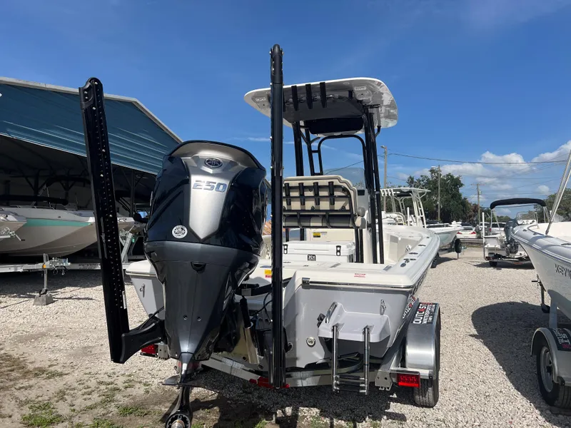 Slide: The Image of 2025 Key West 230 Bay Reef boat with powerful outboard motor, parked on a trailer. - 3