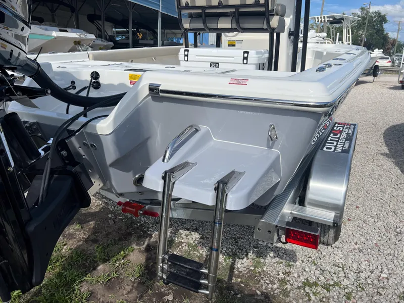 Slide: The Image of 2025 Key West 230 Bay Reef boat with ladder and trailer, parked on gravel. - 4