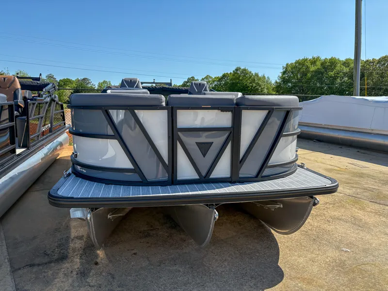 Slide: The Image of 2025 Trifecta 23 RF SS pontoon boat, sleek design, docked outdoors under clear blue sky. - 2