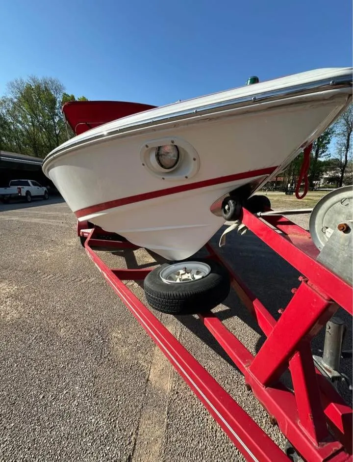 Slide: The Image of 1997 Cobalt 220 boat on red trailer, parked outdoors under clear blue sky. - 2
