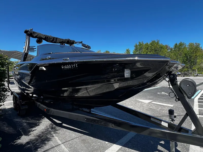 Slide: The Image of 2019 Supreme ZS232 boat on trailer in parking lot under clear blue sky. - 3