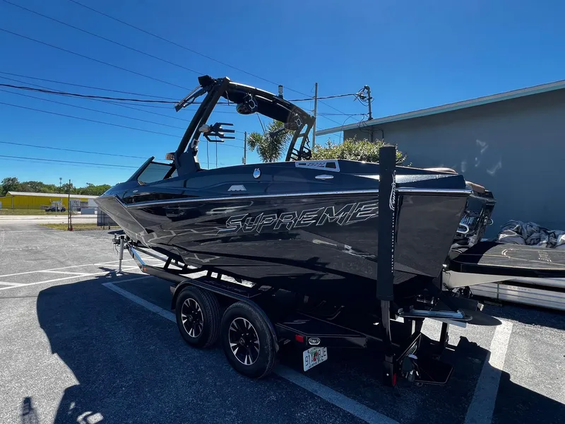 Slide: The Image of 2019 Supreme ZS232 boat on trailer, parked outdoors under clear blue sky. - 6