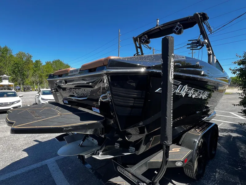 Slide: The Image of 2019 Supreme ZS232 boat with sleek black design, parked on a trailer in a sunny lot. - 7