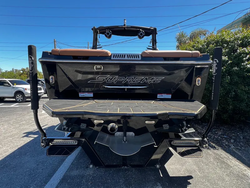 Slide: The Image of 2019 Supreme ZS232 boat rear view in parking lot under clear blue sky. - 8
