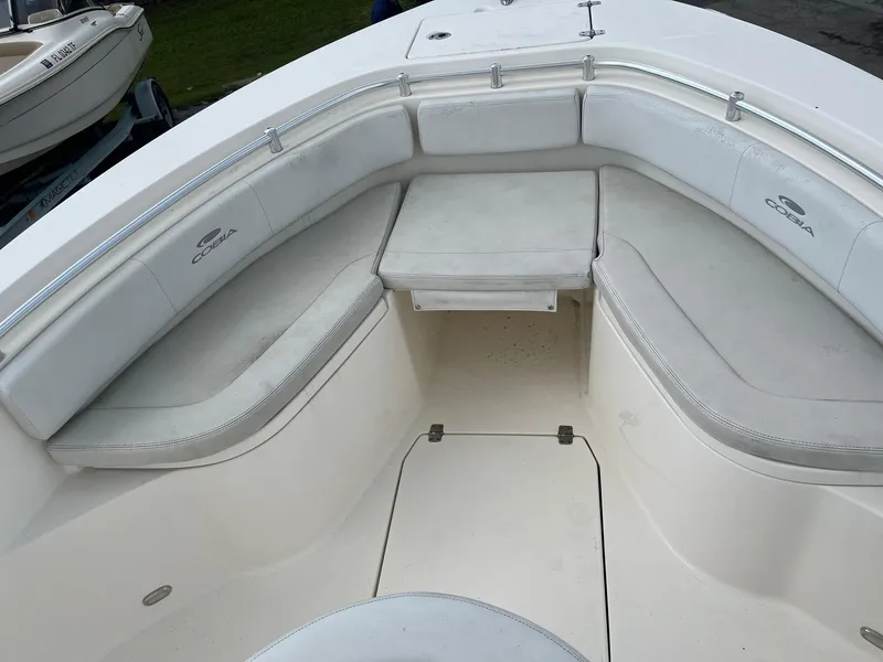Slide: The Image of 2022 Cobia 237 Center Console boat with cushioned seating and table in the bow area. - 8