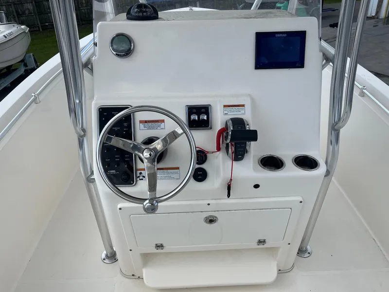 Slide: The Image of 2022 Cobia 237 Center Console boat dashboard with steering wheel and controls. - 9