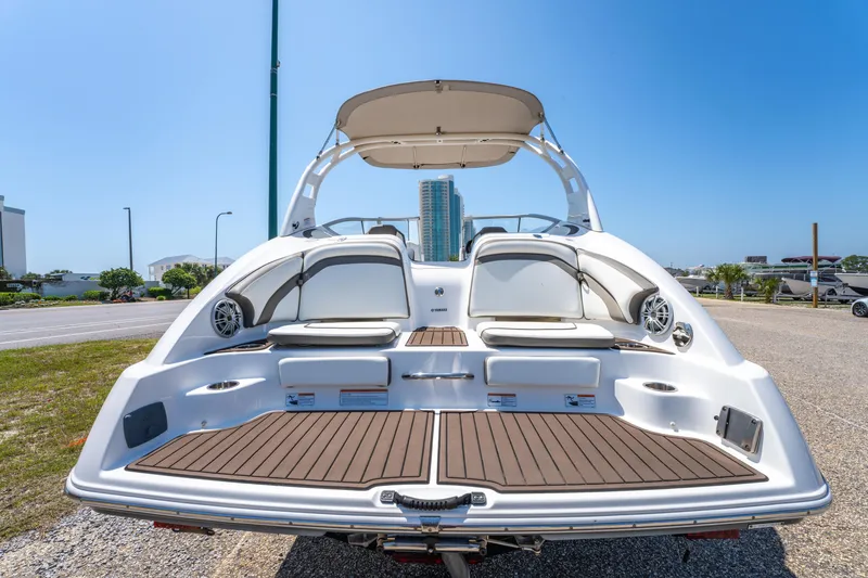Slide: The Image of 2015 Yamaha Boats 242 Limited S, rear view, showcasing spacious deck and seating. - 2