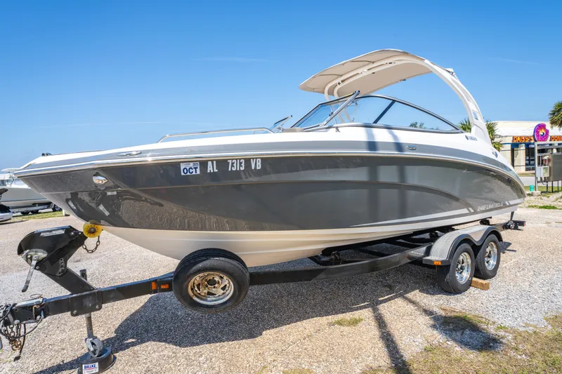 Slide: The Image of 2015 Yamaha Boats 242 Limited S on trailer, parked outdoors under clear blue sky. - 21