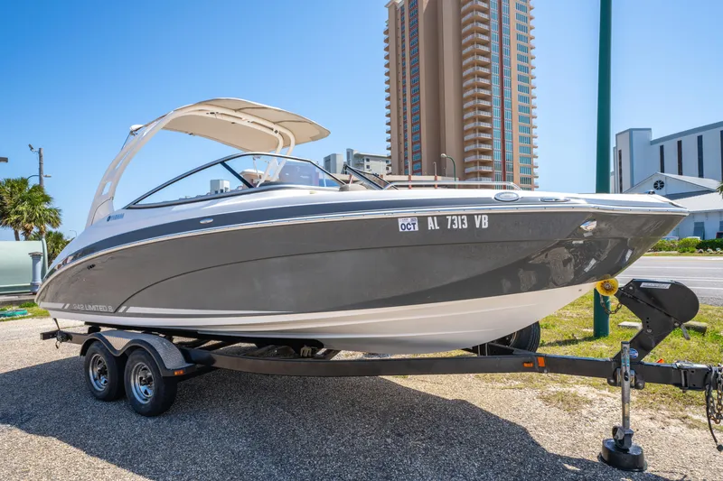 Slide: The Image of 2015 Yamaha Boats 242 Limited S on trailer, parked near tall buildings. - 5