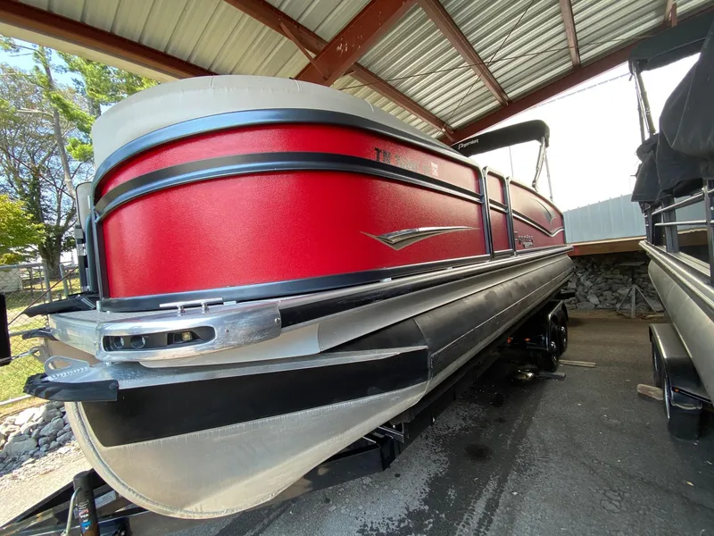 The Image of 2021 Premier 230 Solaris RF pontoon boat in red under a metal roof. - 1