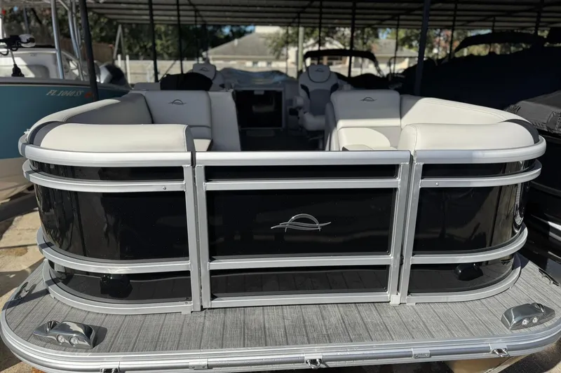 Slide: The Image of 2025 SunCatcher Select 20RC pontoon boat with sleek black and white seating. - 8