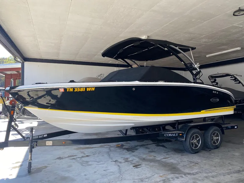 Slide: The Image of 2022 Cobalt CS23 Surf boat on trailer in a garage setting. - 1
