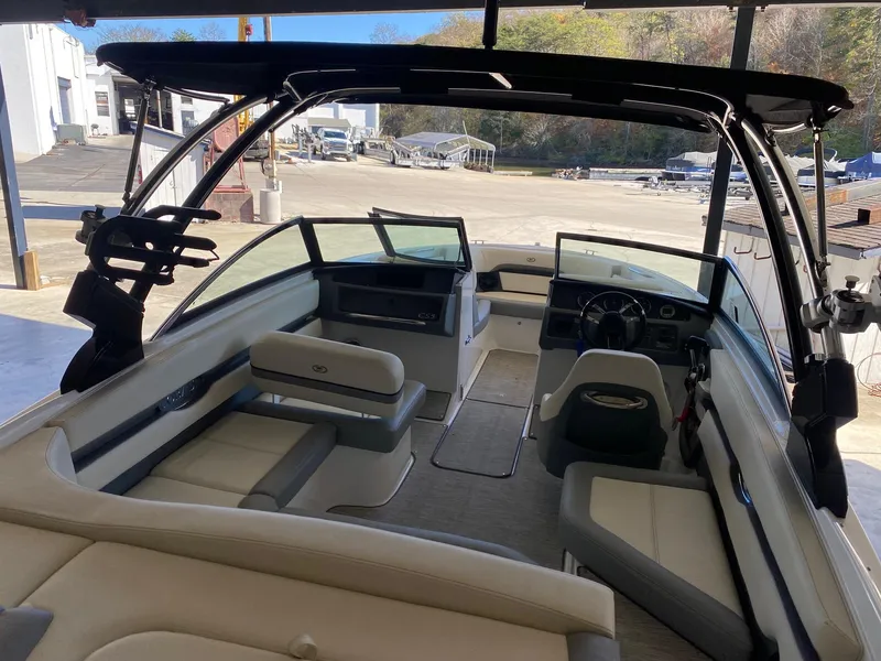 Slide: The Image of 2022 Cobalt CS23 Surf boat interior with seating and dashboard, docked at marina. - 3