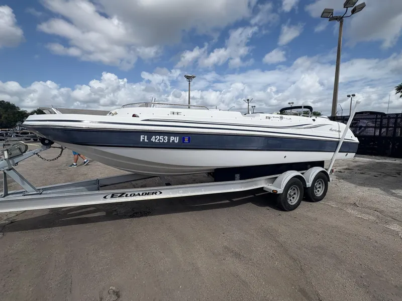 Slide: The Image of 2014 Hurricane SunDeck Sport 232 OB boat on trailer under cloudy sky. - 1