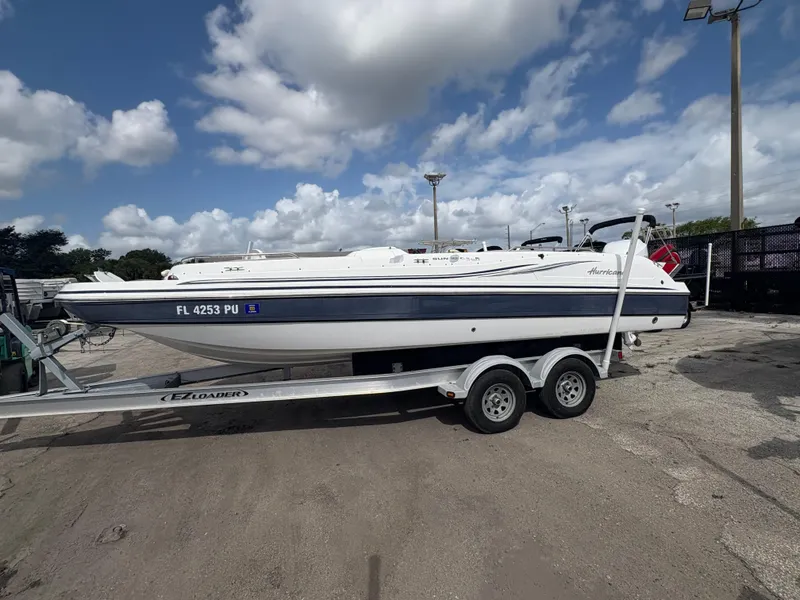 Slide: The Image of 2014 Hurricane SunDeck Sport 232 OB boat on trailer under cloudy sky. - 3