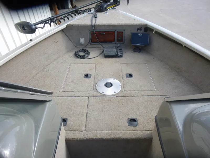 Slide: The Image of 2004 Bass Tracker Targa 16 WT boat interior with carpeted deck and trolling motor. - 23