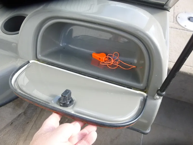 Slide: The Image of Storage compartment in a 2004 Bass Tracker Targa 16 WT boat with an orange whistle inside. - 26