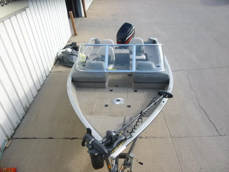 Slide: The Image of 2004 Bass Tracker Targa 16 WT boat with windshield and motor, parked on concrete. - 3