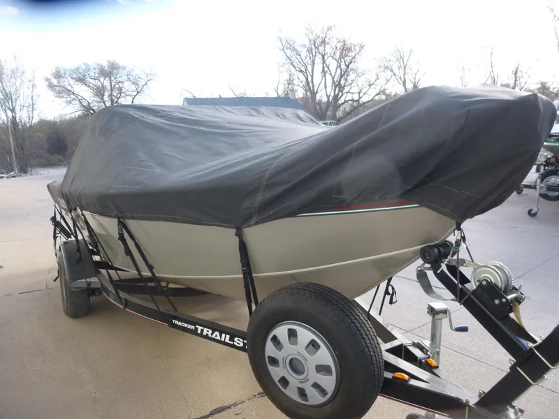 Slide: The Image of 2004 Bass Tracker Targa 16 WT boat covered on trailer, parked outdoors. - 39