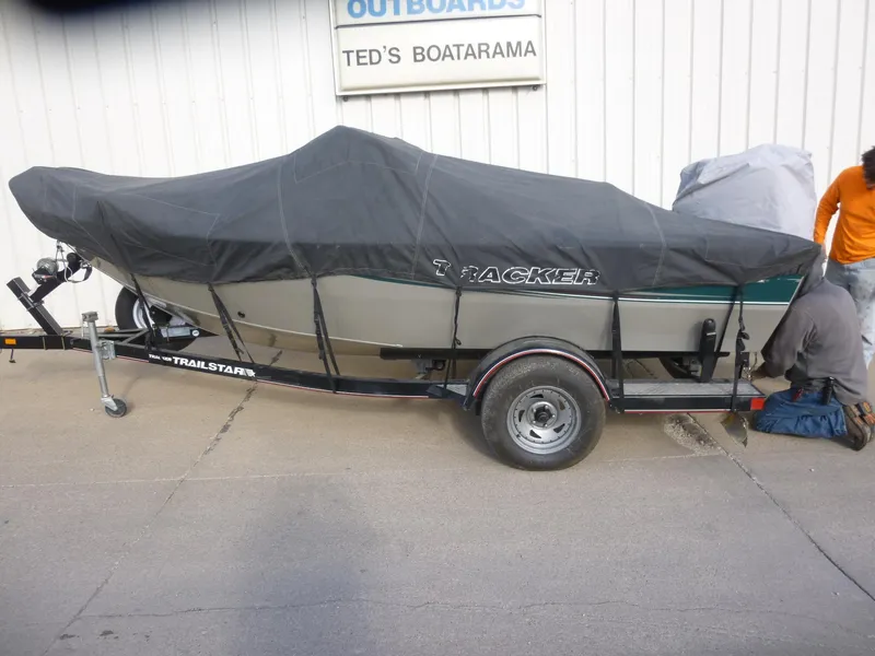 Slide: The Image of 2004 Bass Tracker Targa 16 WT boat covered on a trailer outside Ted's Boatarama. - 4
