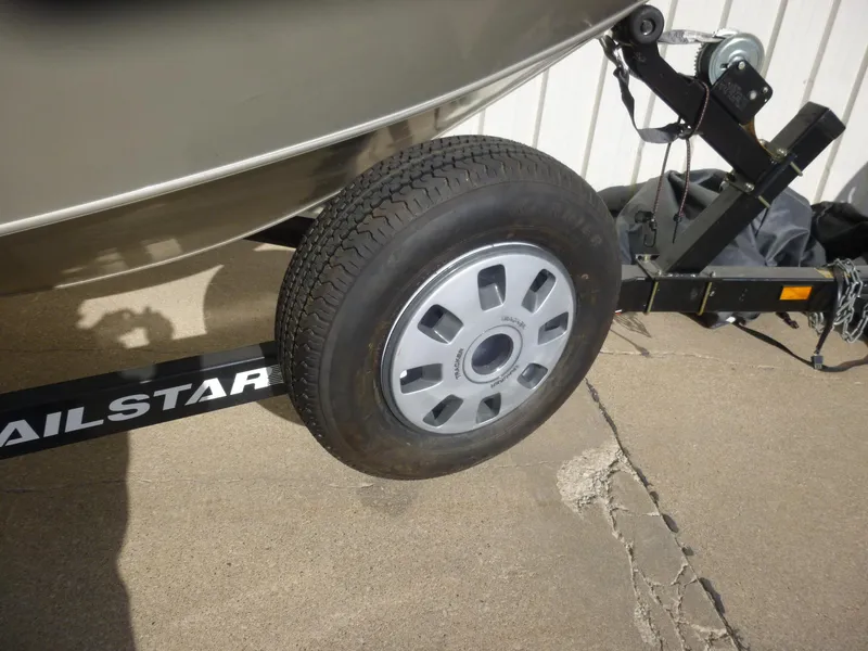Slide: The Image of Trailer wheel of a 2004 Bass Tracker Targa 16 WT boat on concrete surface. - 8