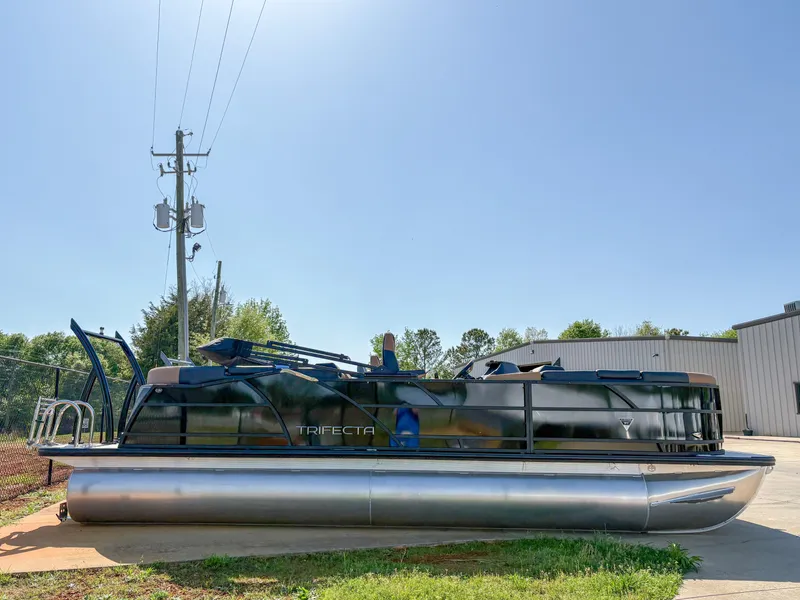 Slide: The Image of 2025 Trifecta 23 RF SS pontoon boat parked outdoors on a sunny day. - 1
