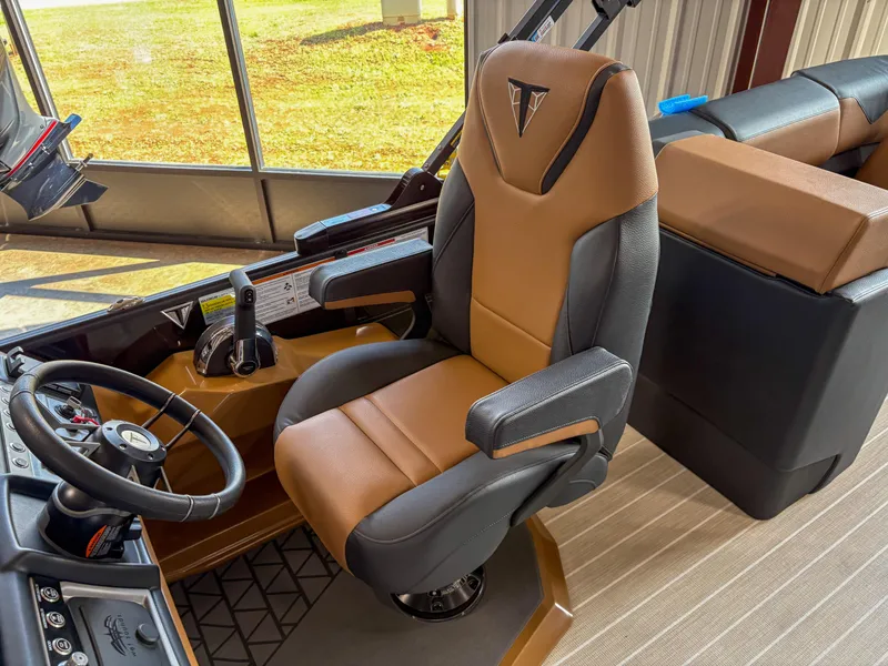 Slide: The Image of Captain's chair in 2025 Trifecta 23 RF SS boat cockpit, featuring modern controls and steering wheel. - 8