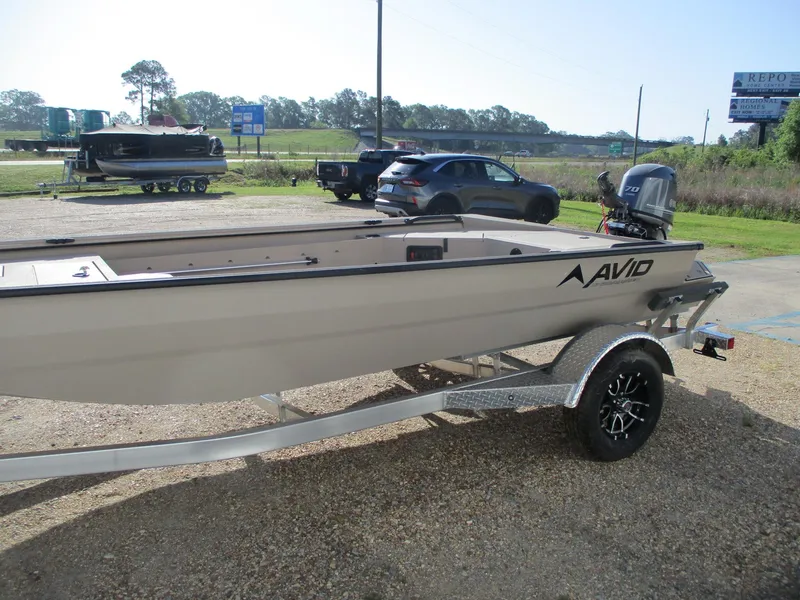 Slide: The Image of 2025 Avid 18 Commander boat on trailer, parked outdoors in a lot. - 4