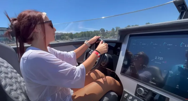 Slide: The Image of Woman steering 2025 Fountain 34 Thundercat boat with modern dashboard display. - 15