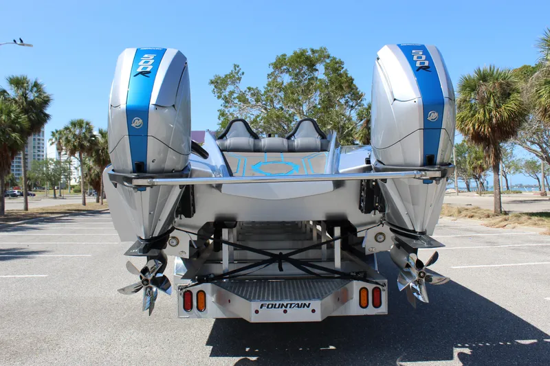 Slide: The Image of 2025 Fountain 34 Thundercat boat with dual outboard engines in a sunny parking lot. - 7