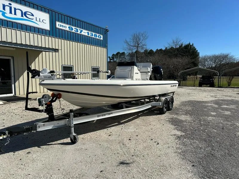 Slide: The Image of 2024 Skeeter SX230 boat on trailer outside a marine dealership. - 2