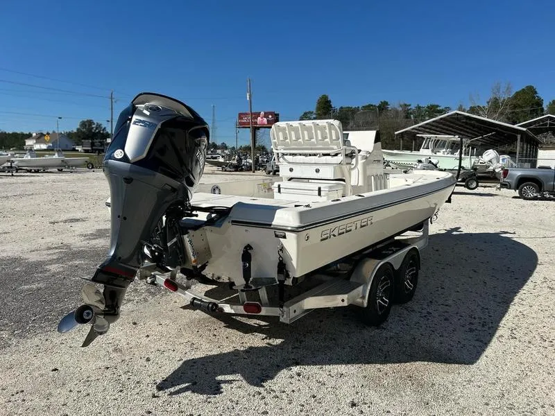 Slide: The Image of 2024 Skeeter SX230 boat on trailer with outboard motor, parked outdoors. - 3