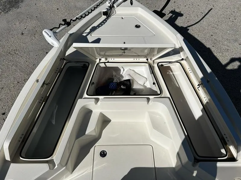 Slide: The Image of 2024 Skeeter SX230 boat with open storage compartments on deck. - 8