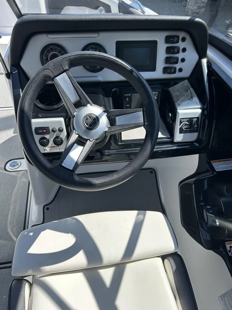 Slide: The Image of 2021 Yamaha Boats SX 210 dashboard with steering wheel and control panel. - 12