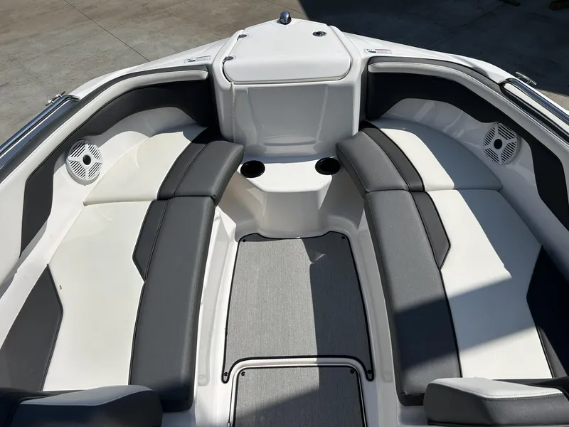 Slide: The Image of 2021 Yamaha Boats SX 210 interior with cushioned seating and cup holders. - 7