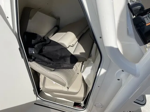 Slide: The Image of Storage compartment in a 2021 Key West 239 FS boat with cushions and a black bag. - 12