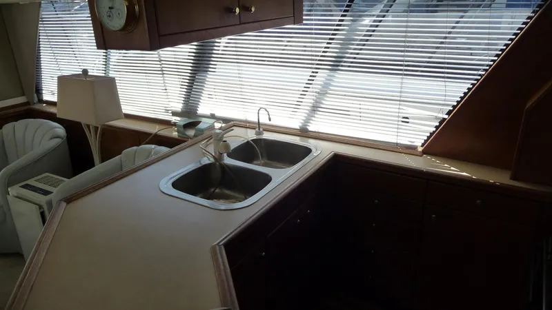 Slide: The Image of Interior of 1995 Bayliner 4788 Pilot House Motoryacht kitchen with dual sinks and blinds. - 16
