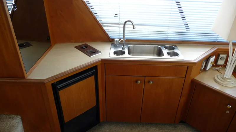 Slide: The Image of Compact kitchen area in a 1995 Bayliner 4788 Pilot House Motoryacht with sink and mini fridge. - 17