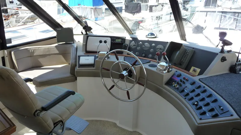 Slide: The Image of 1995 Bayliner 4788 Pilot House Motoryacht helm with steering wheel and control panel. - 19
