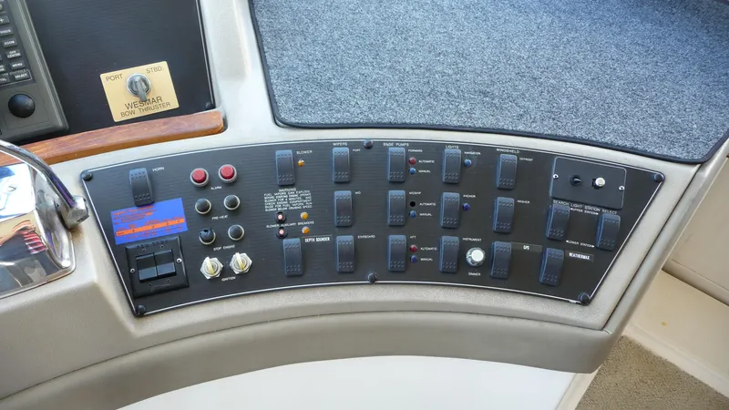 Slide: The Image of Control panel of a 1995 Bayliner 4788 Pilot House Motoryacht with various switches and buttons. - 25