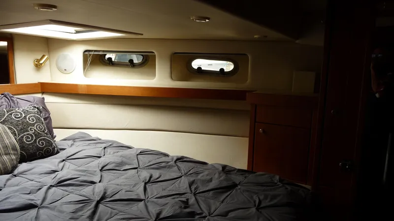 Slide: The Image of Cozy bedroom interior of 1995 Bayliner 4788 Pilot House Motoryacht with portholes and bedding. - 34