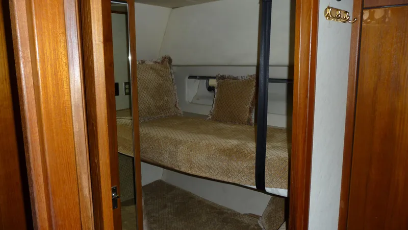 Slide: The Image of 1995 Bayliner 4788 Pilot House Motoryacht cabin with cozy bunk bed and wooden interior. - 39