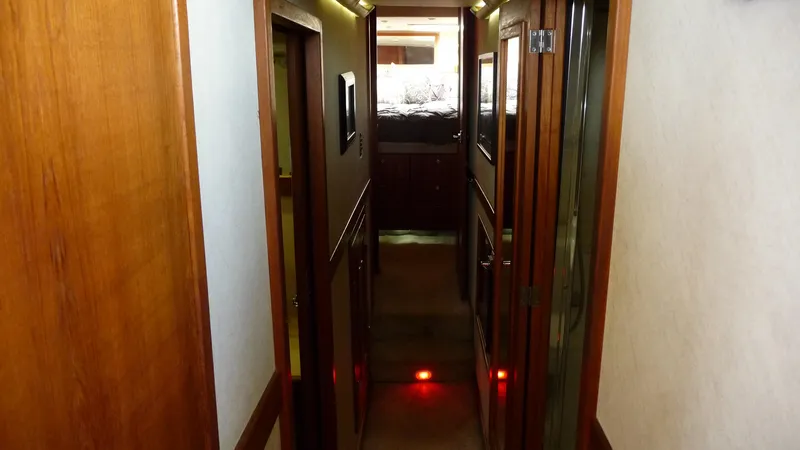Slide: The Image of 1995 Bayliner 4788 Pilot House Motoryacht interior hallway with wood paneling and ambient lighting. - 42