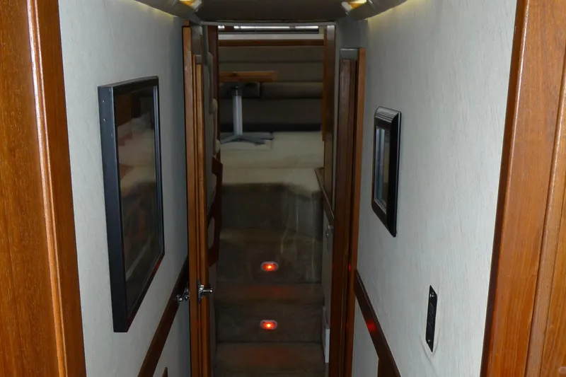 Slide: The Image of Interior hallway of 1995 Bayliner 4788 Pilot House Motoryacht with wooden accents and framed artwork. - 43