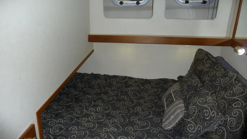 Slide: The Image of Cozy cabin interior of 1995 Bayliner 4788 Pilot House Motoryacht with patterned bedding. - 44