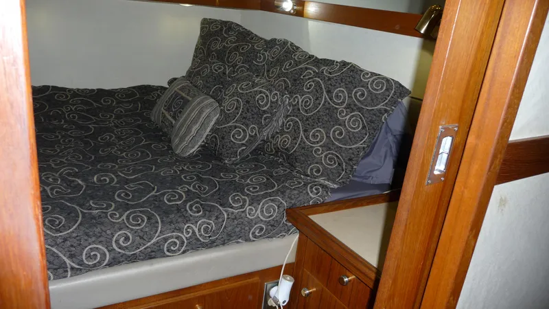 Slide: The Image of Cozy bedroom in 1995 Bayliner 4788 Pilot House Motoryacht with patterned bedding and wooden accents. - 45