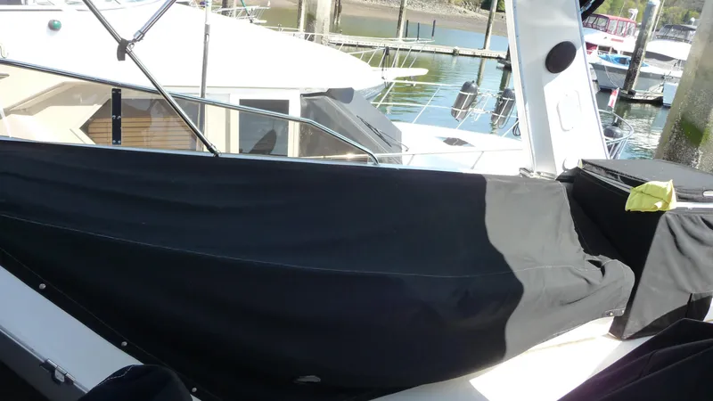 Slide: The Image of 1995 Bayliner 4788 Pilot House Motoryacht docked, covered with black canvas. - 49