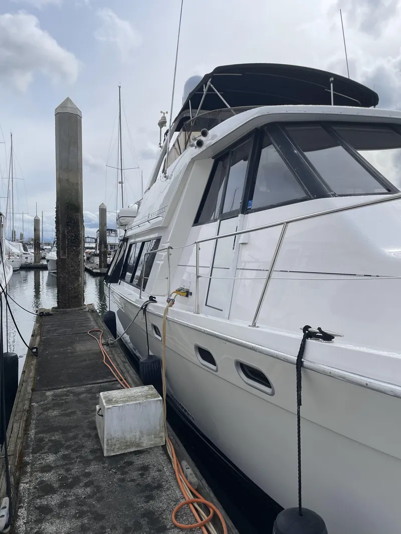 Slide: The Image of 1995 Bayliner 4788 Pilot House Motoryacht docked at marina, overcast sky. - 5