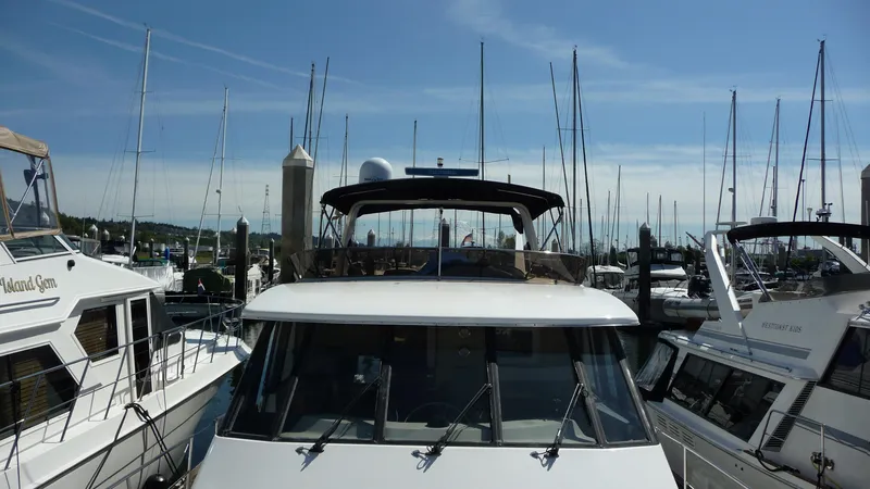 Slide: The Image of 1995 Bayliner 4788 Pilot House Motoryacht docked at marina, surrounded by sailboats. - 7