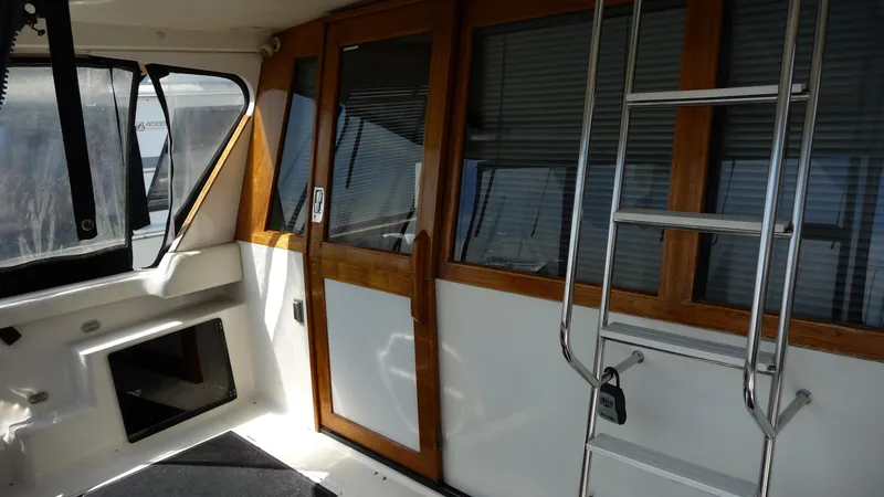 Slide: The Image of Interior view of 1995 Bayliner 4788 Pilot House Motoryacht with wooden doors and ladder. - 8